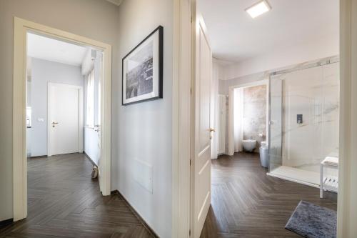 korytarz z białymi ścianami i drewnianą podłogą oraz łazienką w obiekcie Vista Sulle Colline w Forli