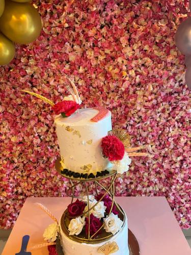 a three tiered cake on a table with flowers at Shomaan boutique hotel in Sundarnagar