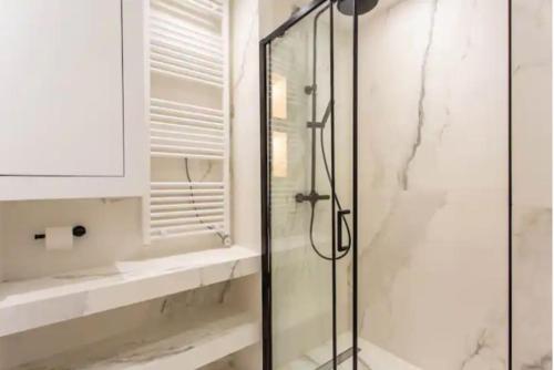 une salle de bain avec une douche avec une porte vitrée dans l'établissement Central Apartment Tronchet 1G, à Paris