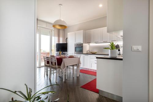 a kitchen with white cabinets and a table with chairs at Forlì Park View in Forlì