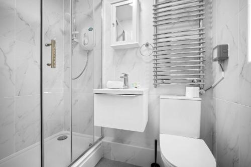 y baño blanco con aseo y ducha. en Luxury 3 Bedroom Apartment - Terrace - WiFi - Smart TV 1MR en Birmingham