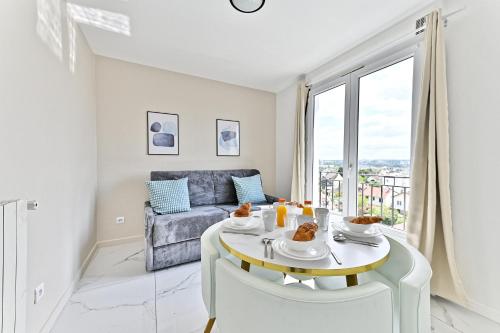 sala de estar blanca con mesa y sofá en Appartement proche de Paris - Gagny, en Gagny