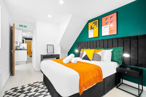 a bedroom with a large bed with an orange blanket at Modern 3 Bedroom Apartment - Terrace - Near City Centre - WiFi - Smart TV 1MR in Birmingham