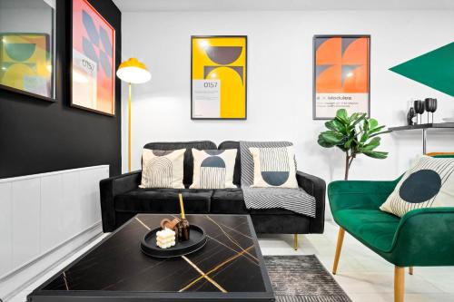 a living room with a black couch and a green chair at Modern 3 Bedroom Apartment - Terrace - Near City Centre - WiFi - Smart TV 1MR in Birmingham