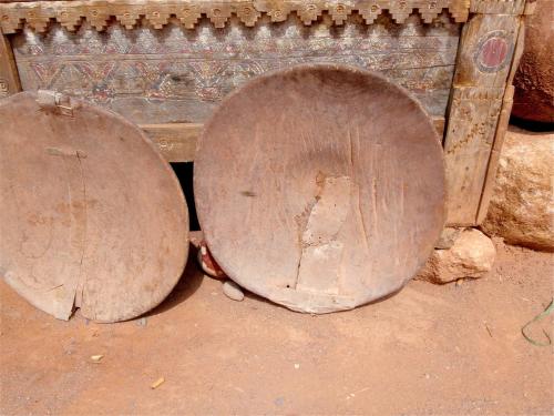 two old wooden drums sitting on the ground at Kasbah Titrit & Spa in Aït Ben Haddou