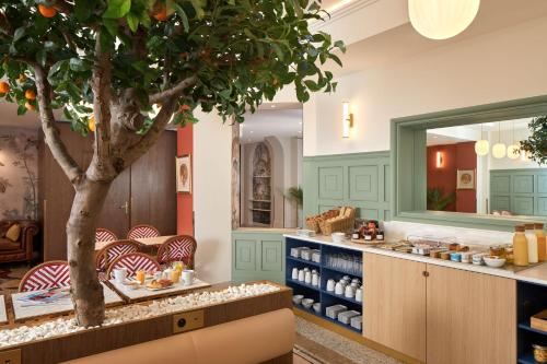 un restaurant avec un arbre au milieu d'une pièce dans l'établissement Timhotel Palais Royal, à Paris
