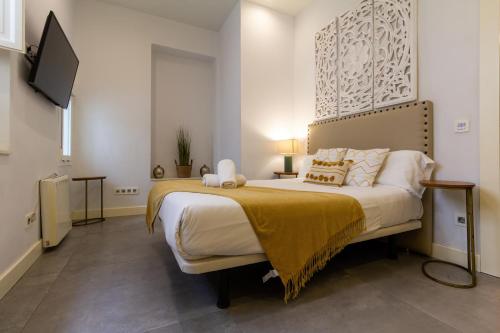 セビリアにあるConteros Dúplex - Terraza vistas a la Giraldaのベッドルーム1室(大型ベッド1台、黄色い毛布付)