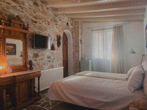 a bedroom with a bed and a tv on the wall at Villa Art Natalie two in Kithnos