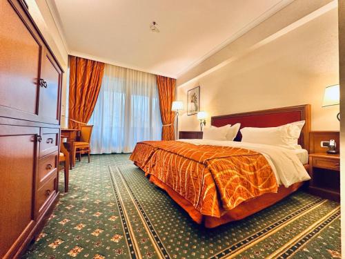 a hotel room with a bed and a large window at Lux Garden Hotel in Azuga