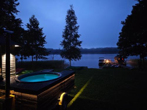a backyard with a jacuzzi tub next to a lake at Atpūtas vieta Ežezers in Andzeļi