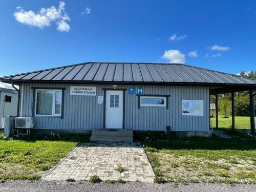 a small grey building with a sign on it at Lõunaranna Harbour Accommodation in Simisti