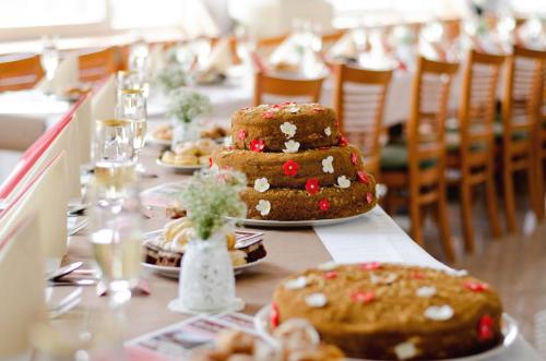 una mesa larga con tres pasteles encima en Hotel Bila Ruze, en Písek