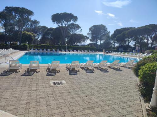 - une piscine avec un groupe de chaises à côté dans l'établissement Charmant 2 pièces au cœur des Golfs de Saint Raphael, à Saint-Raphaël
