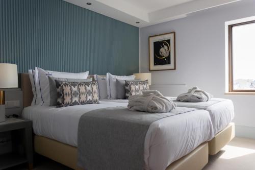 2 Betten in einem Schlafzimmer mit grünen Wänden in der Unterkunft VIP Executive Suites do Marquês Hotel in Lissabon