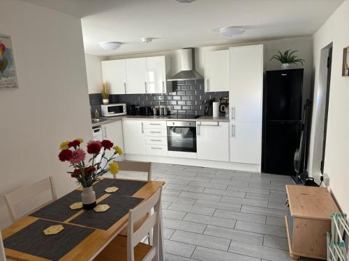 a kitchen with a table and a black refrigerator at Comfort Zone in Colchester