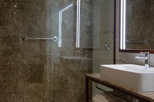 里斯本的住宿－VIP Executive Suites do Marquês Hotel，一间带水槽和淋浴的浴室