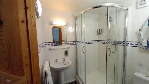 a bathroom with a glass shower and a sink at Treliver Farm in Saint Wenn