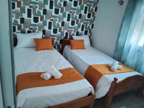 1 dormitorio con 2 camas y toallas. en Casa da Pitoquinha II en Casais do Rio