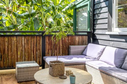 a patio with a couch and a table at Jungle Cottage Escape in Auckland