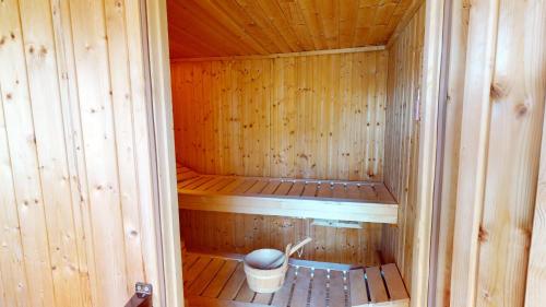 a small wooden sauna with a bucket in it at 54° Nord Wohnung 1 in Grömitz