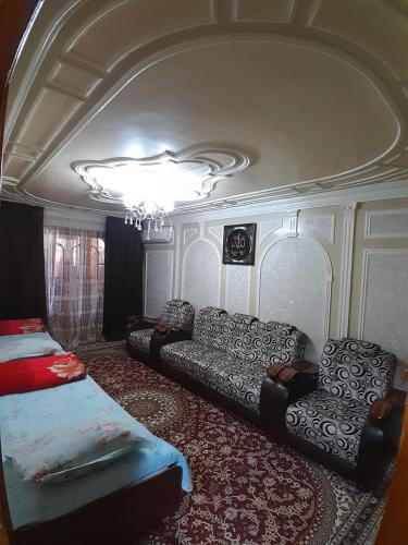 - un salon avec un canapé et un lit dans l'établissement Dilshoda hi-tech, à Samarcande