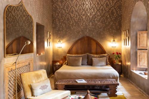 ein Schlafzimmer mit einem Bett und einem Stuhl in einem Zimmer in der Unterkunft La Villa Nomade in Marrakesch