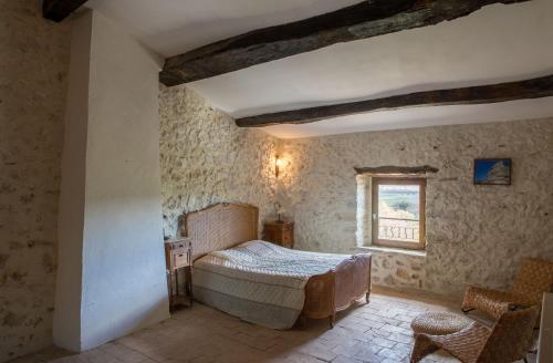 een slaapkamer met een bed en een raam bij Le Petit Nid au Mas de Causse in Brissac