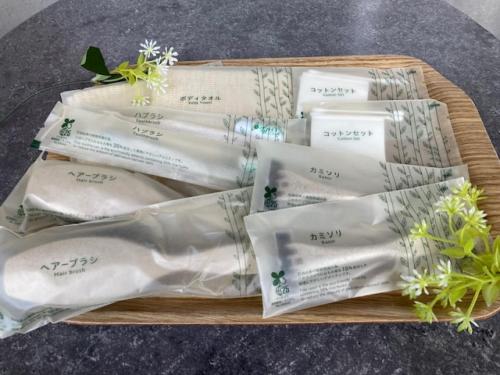 a tray of packaged towels with flowers on top at The BREAKFAST HOTEL MARCHE Ishigaki Island in Ishigaki Island