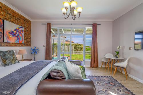 a bedroom with a large bed with a couch at Flensborg Studios & Penthouse - Langebaan Golf Estate in Langebaan