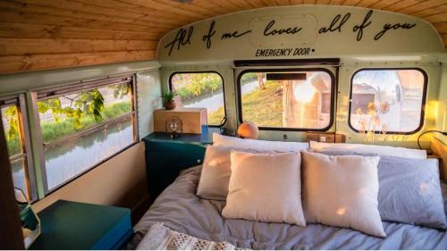 een slaapkamer met een bed en twee ramen in een trein bij Papillon Country Resort in Denekamp