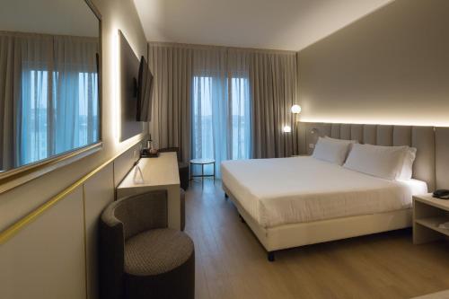 um quarto de hotel com uma cama e uma cadeira em Hotel Nasco em Milão