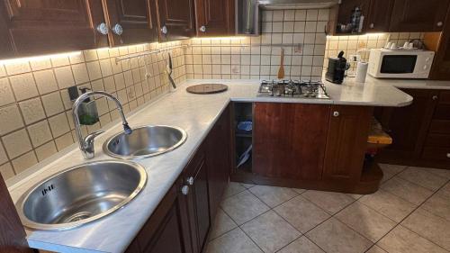 a kitchen with two sinks and a microwave at Casa di Giovanni - Italien in Muggia