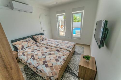 a small bedroom with a bed and a tv at Villa Green in Mostar