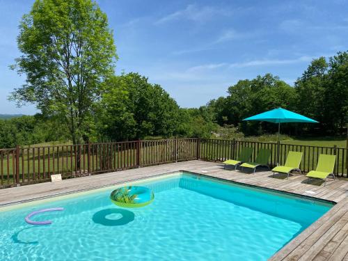 une piscine avec des chaises et un parasol dans l'établissement Chalet les chênes verts - Périgord proche grottes de Lascaux, à Saint-Amand-de-Coly