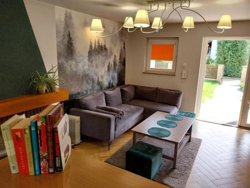 a living room with a couch and a table with books at Domek Chmiel I nad Jeziorem Tarnobrzeskim in Chmielów