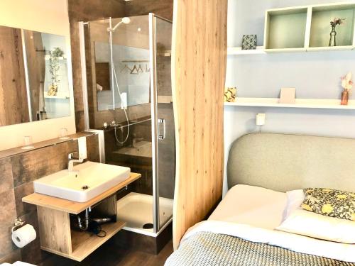 a bathroom with a sink and a shower and a bed at R & J Hotel in Rust