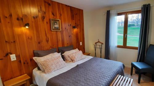 - une chambre avec un lit doté de murs en bois et d'une fenêtre dans l'établissement Domaine de Mezeyrac - Laguiole, à Soulages-Bonneval