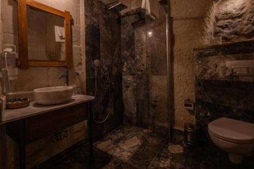 a dirty bathroom with a shower and a sink at Aydinli Cave Hotel in Göreme