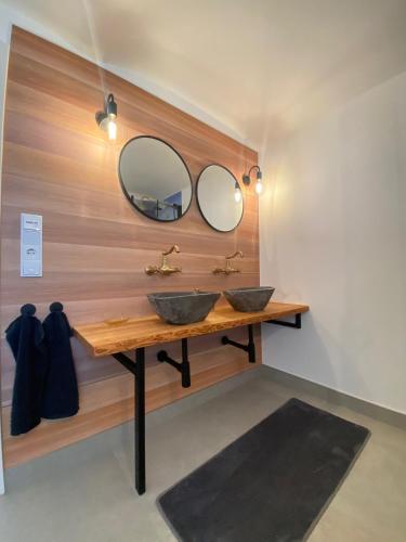 two sinks in a bathroom with two mirrors at MAJA Der SpreeGarten in Cottbus