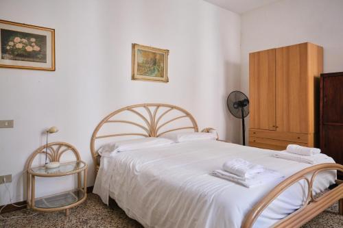 1 dormitorio con 1 cama con sábanas blancas y toallas en Lustraferi Apartment, en Venecia