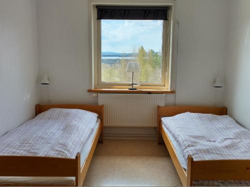two beds in a room with a window at STF Orsa Hostel in Orsa