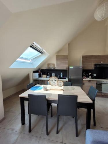 a table and chairs in a kitchen with a window at Résidence Malouine "les roses de Malo les bains" Appartement avec mezzanine in Dunkerque