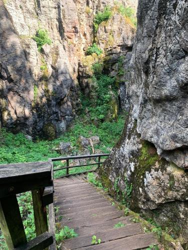 a wooden boardwalk leading up to a rocky mountain at Prána Apartman in Herend