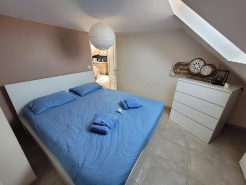 une chambre avec un lit bleu avec des oreillers bleus dans l'établissement Résidence Malouine 