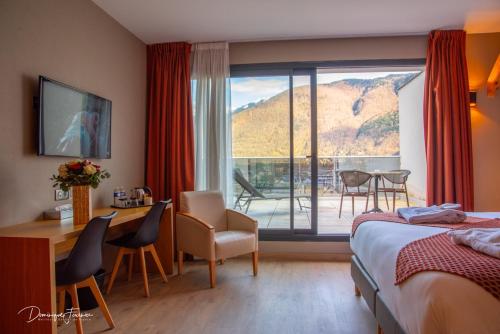 una camera d'albergo con letto, scrivania e tavolo di LE CASTEL D'ALTI a Luchon