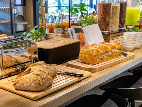 zwei Brotlaibe auf Schneidetafeln auf einem Tisch in der Unterkunft ibis Grenoble Centre Bastille in Grenoble