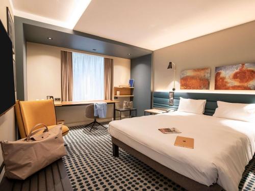 um quarto de hotel com uma cama e uma secretária em Novotel Luxembourg Kirchberg em Luxemburgo