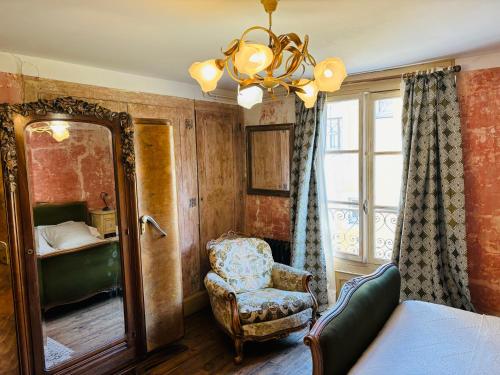 una camera da letto con specchio, sedia e specchio di Epicerie Vieille du Puy en Velay a Le Puy en Velay