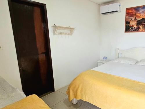 a bedroom with a bed and an open door at Pousada Flor de Lótus Suites Carneiros in Tamandaré