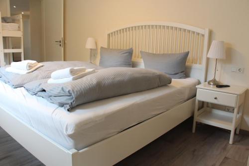 a large white bed with two pillows on it at REGIOHOTEL Aparthotel Wernigerode in Wernigerode